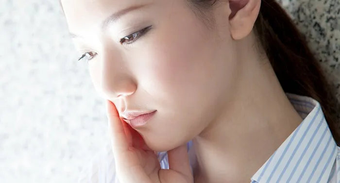 頬を抑えている女性